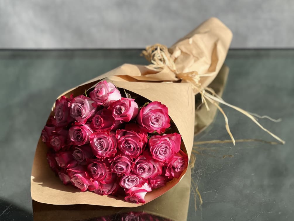 A bouquet of 24 lavender roses with hot pink tips is a
