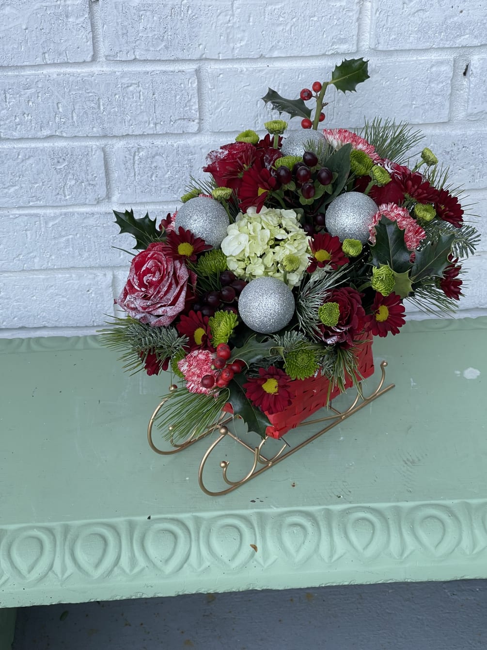 This beautiful sleigh is filled with a variety of christmas flowers, greenery