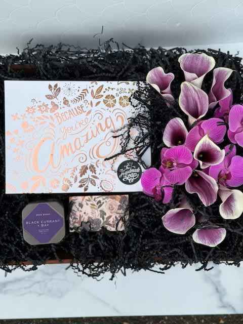 A beautiful display in a wooden crate filled with purple florals, and