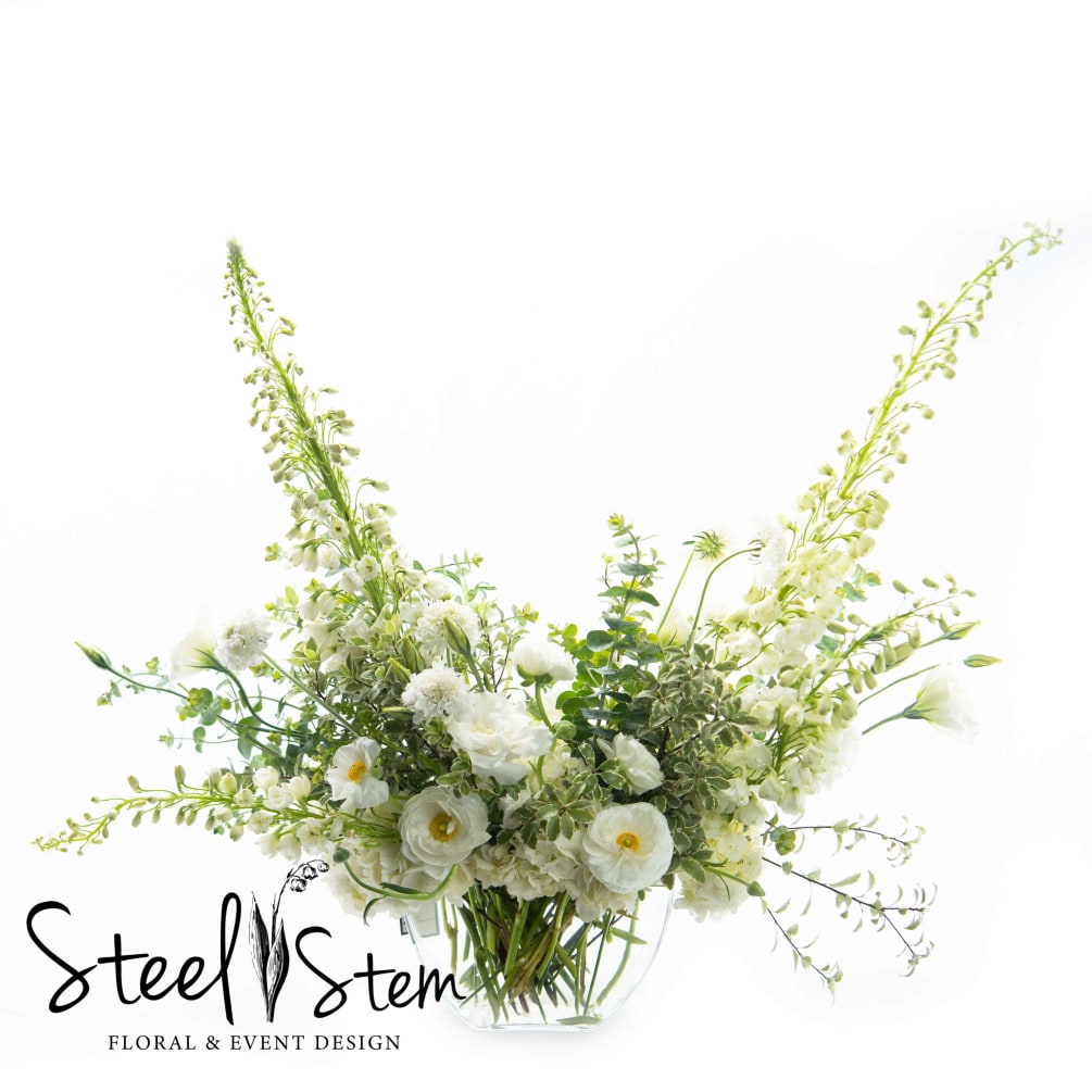 A natural and whimsical design of all white florals featuring fresh ranunculus