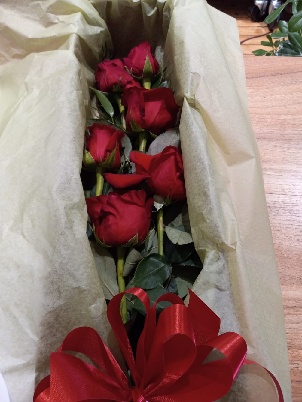 Beautiful red roses boxed with some greens and a bow.