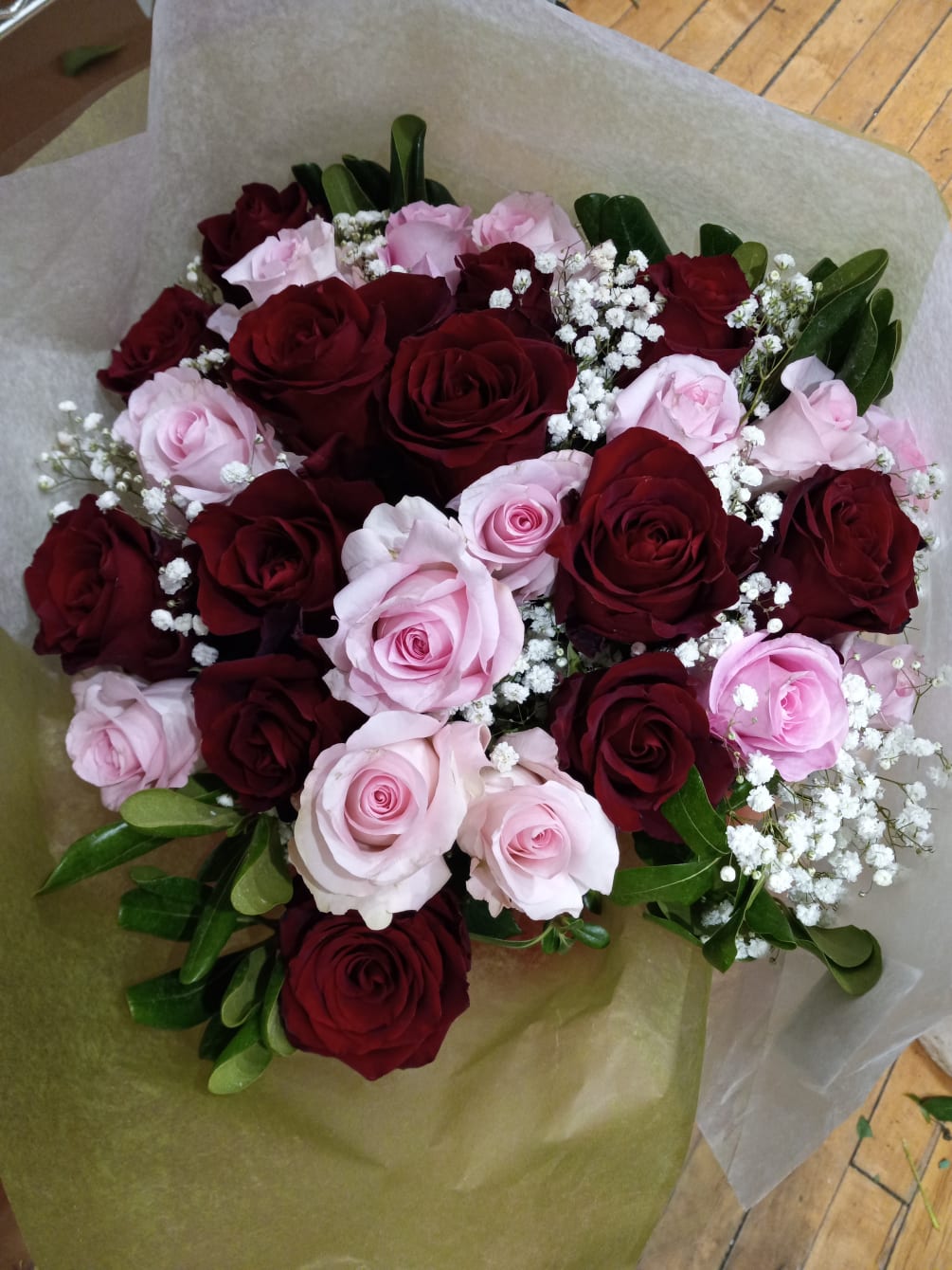beautiful well rounded hand tied bouquet of red and pink roses with