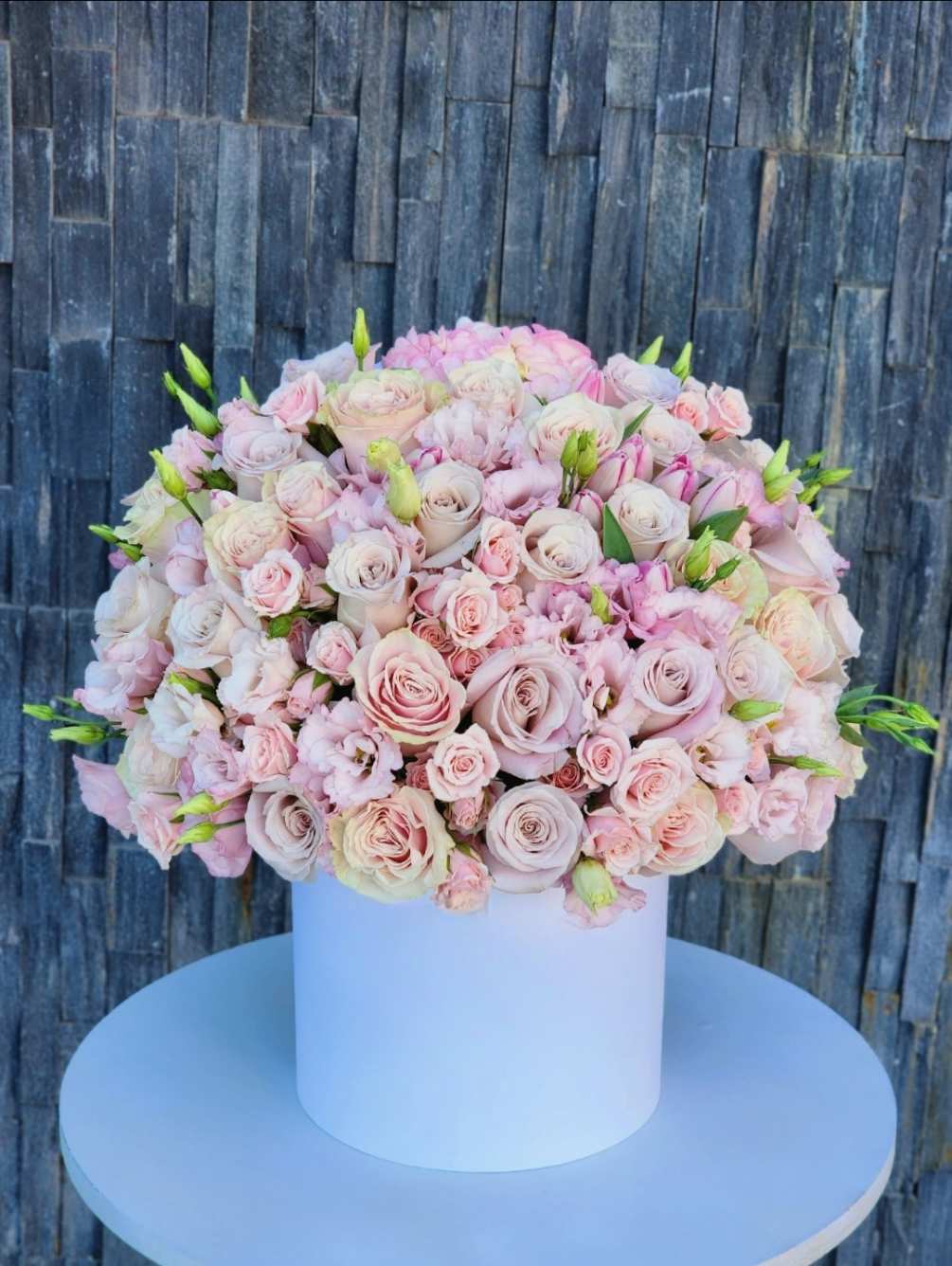 The lush pink mix of flowers arranged in a white elegant box