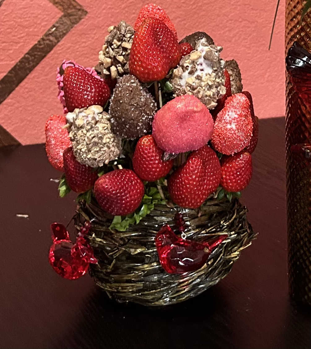A birds nest basket arranged with hand dipped chocolate strawberries in a