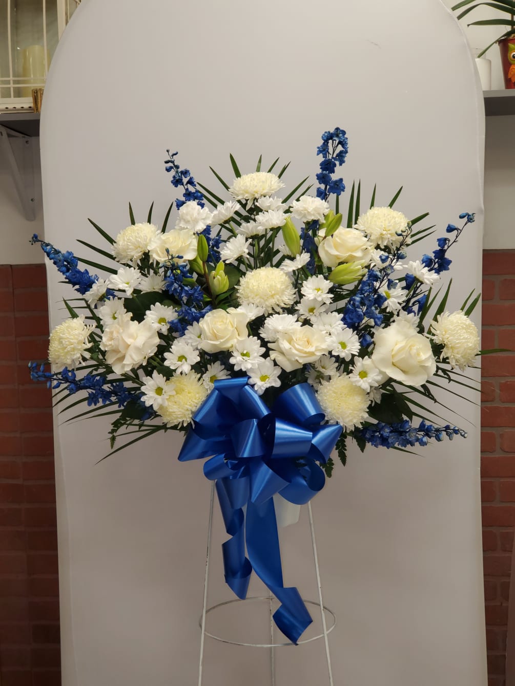 This Blue and White standing basket includes, 8 white mums, 8 blue