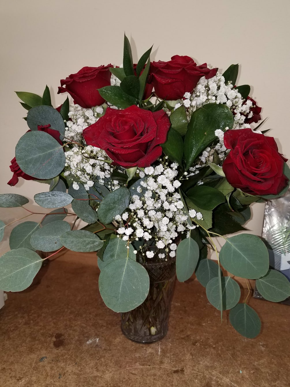 6 beautiful red roses in a vase with baby breath and greens