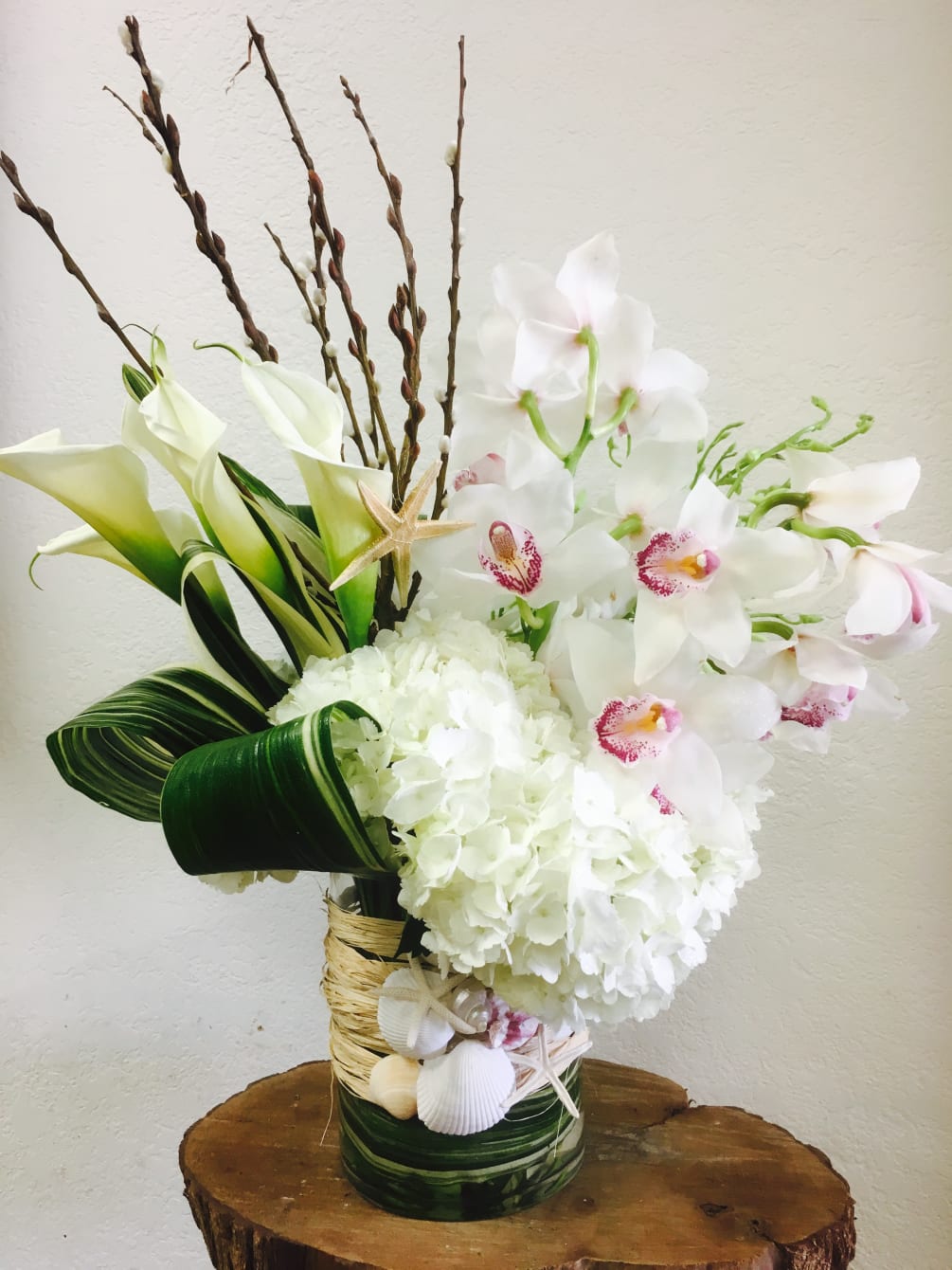 Elegant, beach themed arrangement all in White.  Hydrangeas, calla lilies, cymbidium