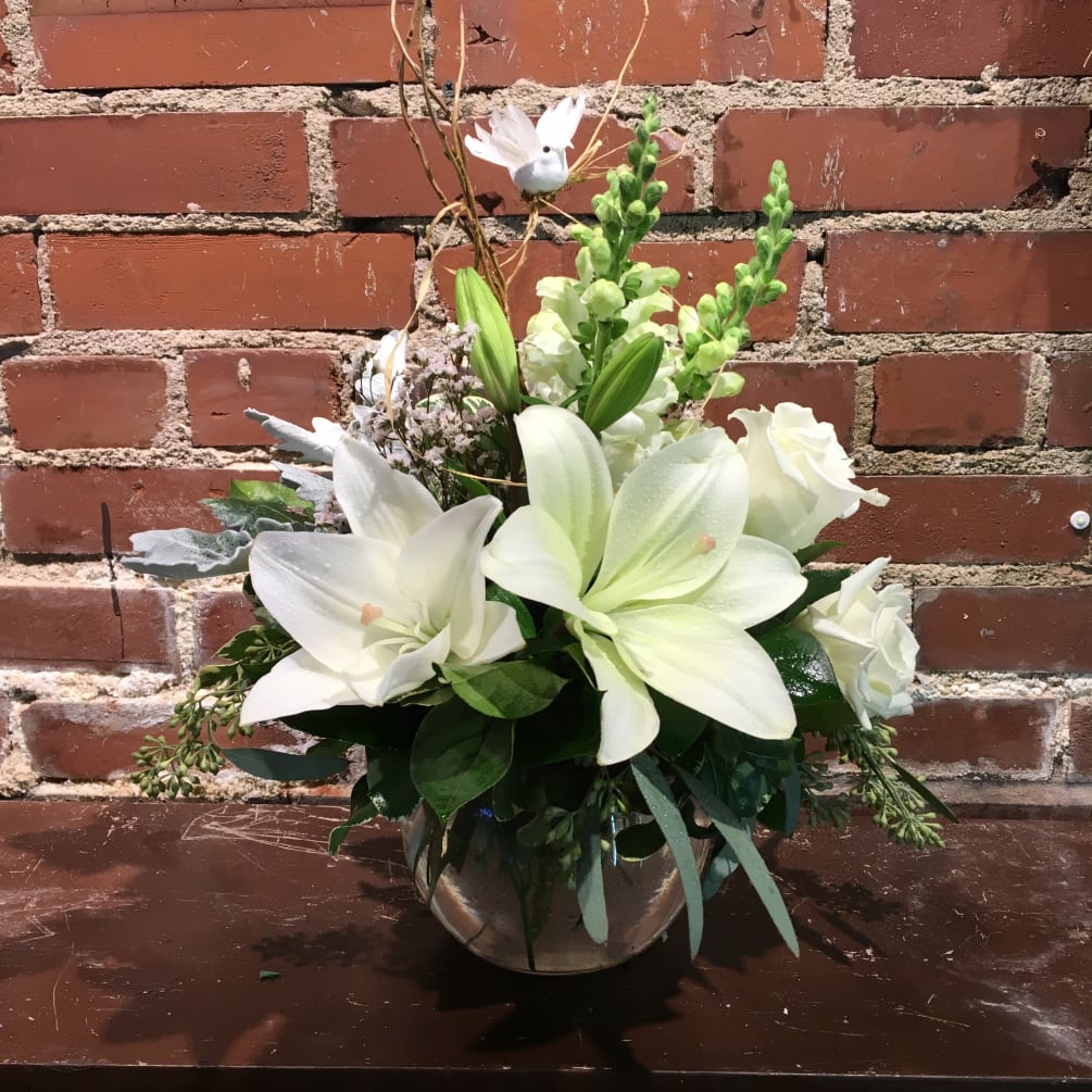 A beautiful arrangement of white blossoms in a bubble bowl with assorted