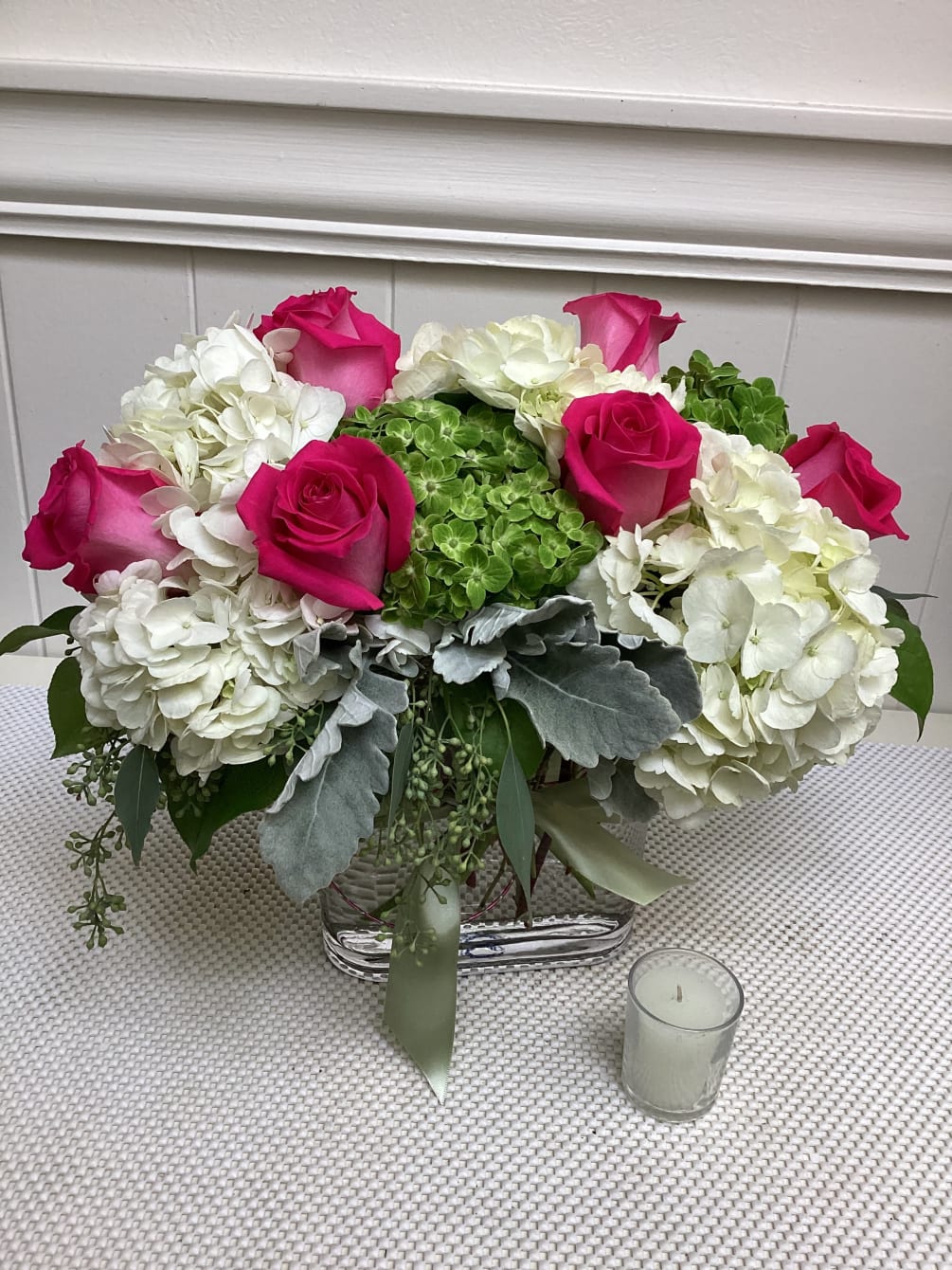 A vibrant arrangement of roses, hydrangea and bright mini-hydrangea. 