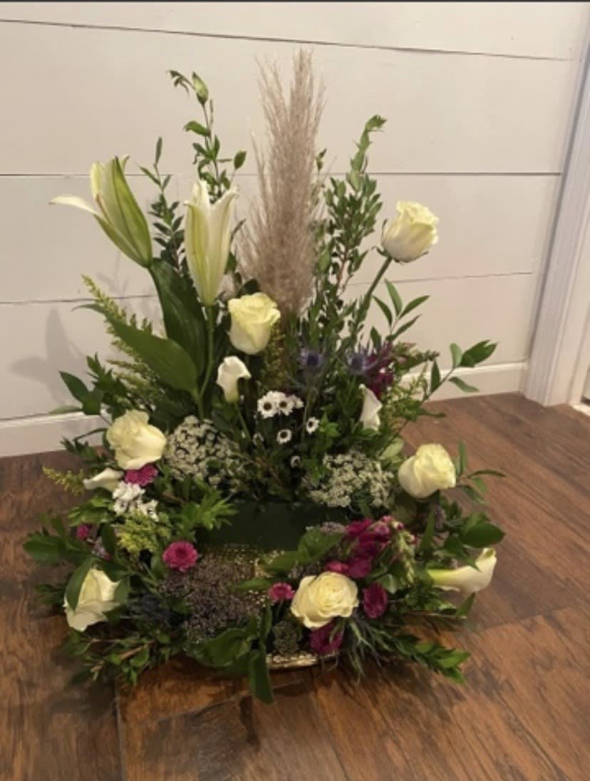 Urn Surround featuring pampas grass, roses, lilies, and other florals. 
