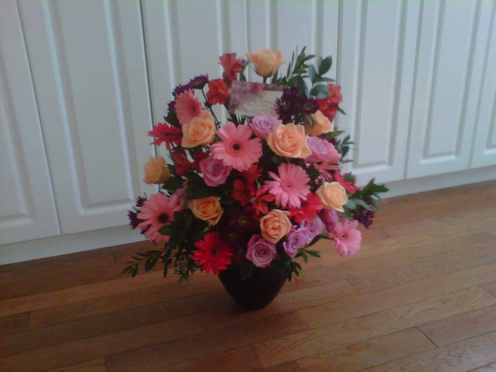 This gorgeous arrangement of colorful gerbera daisies, roses and other flowers are