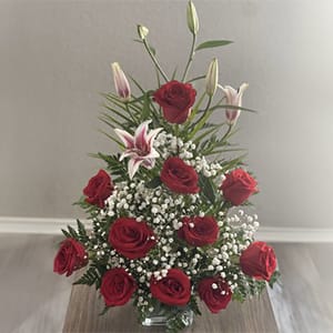 This elegant flower arrangement of long stem red roses, asiatic lilies, baby&rsquo;s