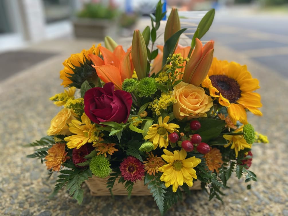 A lively arrangement with roses, sunflowers, lilies and more. Perfect for the