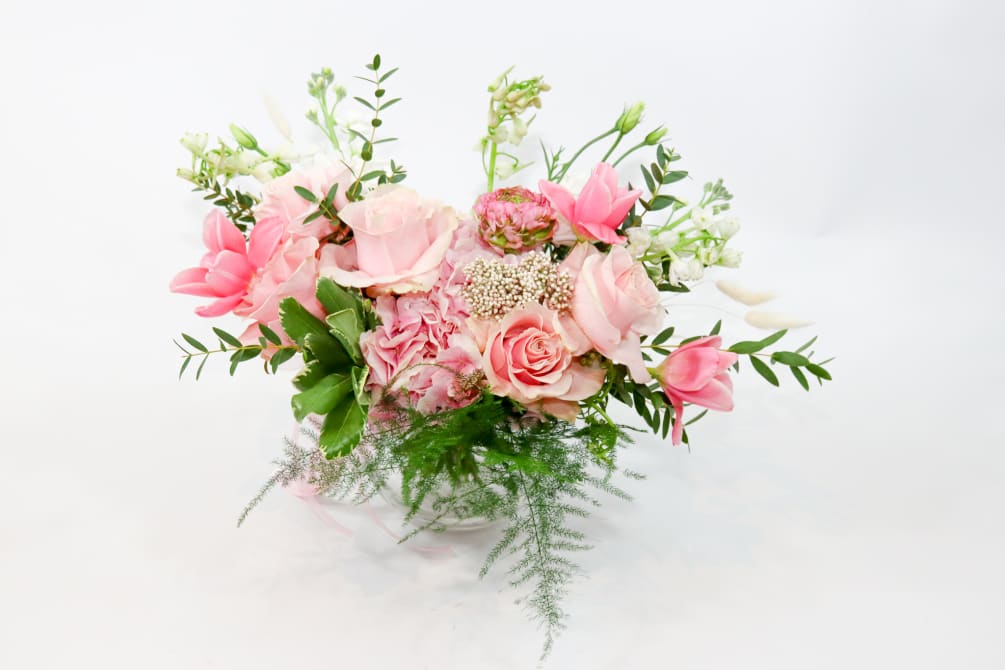 This brilliant arrangement of pink flowers brings some sunshine and vibrant color