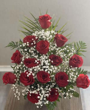 This stunning floral arrangement contains red roses, baby&rsquo;s breath flowers, leather leaf