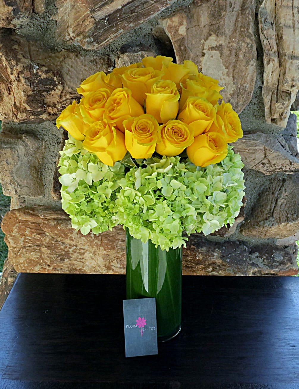 Yellow roses and hydrangeas arranged in a glass vase