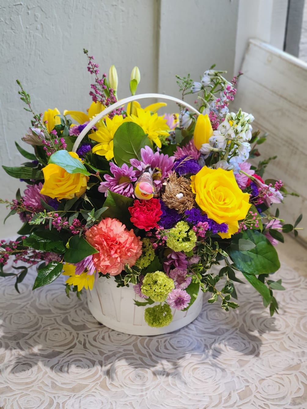 A cute spring basket with bright colors accented with curly willow and