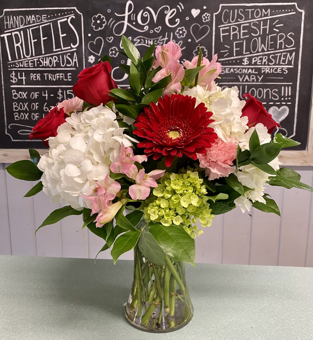 Red roses, pink carnations, red gerber daisy, pink alstromeria, white hydrangea, green