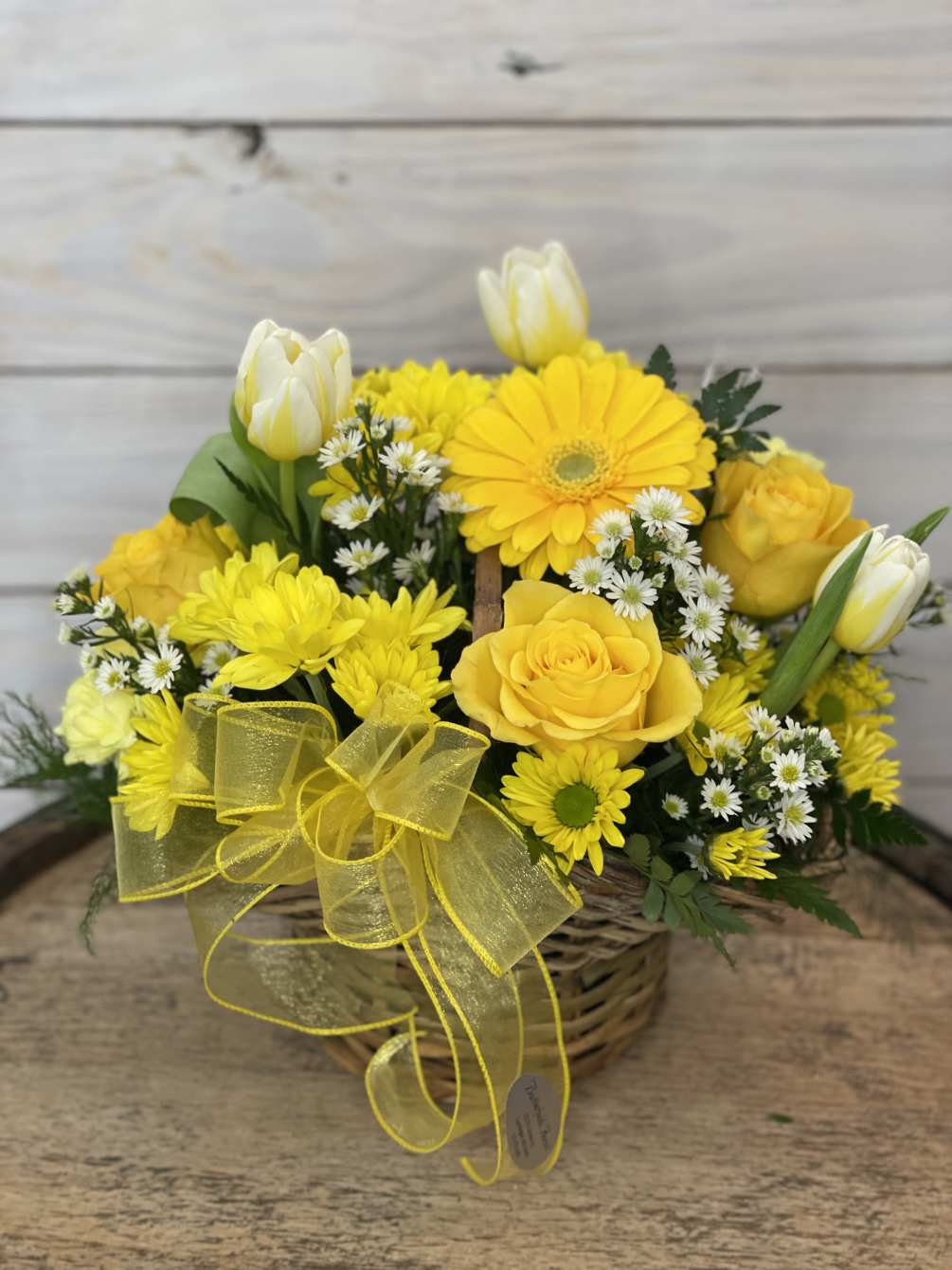 An all yellow basket arrangement of gerbera daisies, solidago, daisies, &amp; roses.