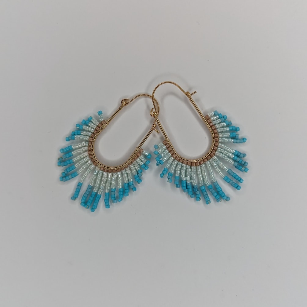Turquoise latch hook earrings embellished with delicate beads for a stylish statement.