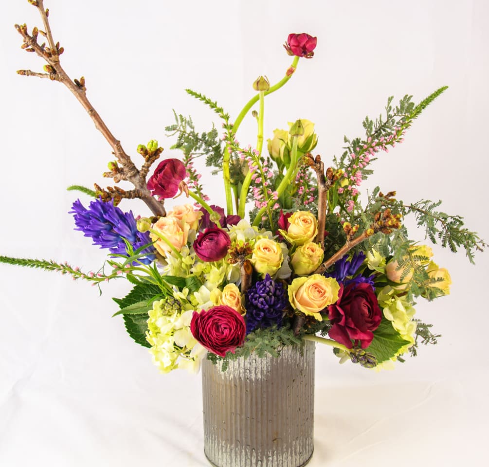 Tall arrangement with a rustic look in tin can. A grand gesture