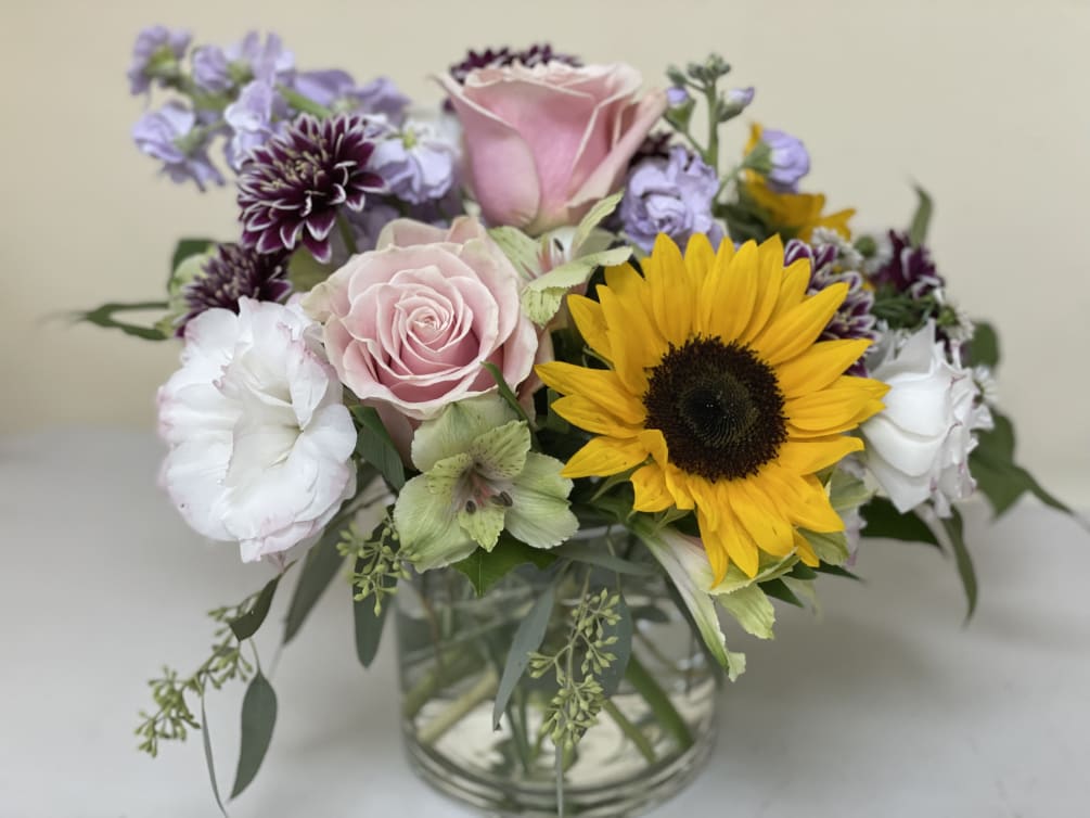 A gentle colored seasonal flower arrangement which is perfect for any occasion.