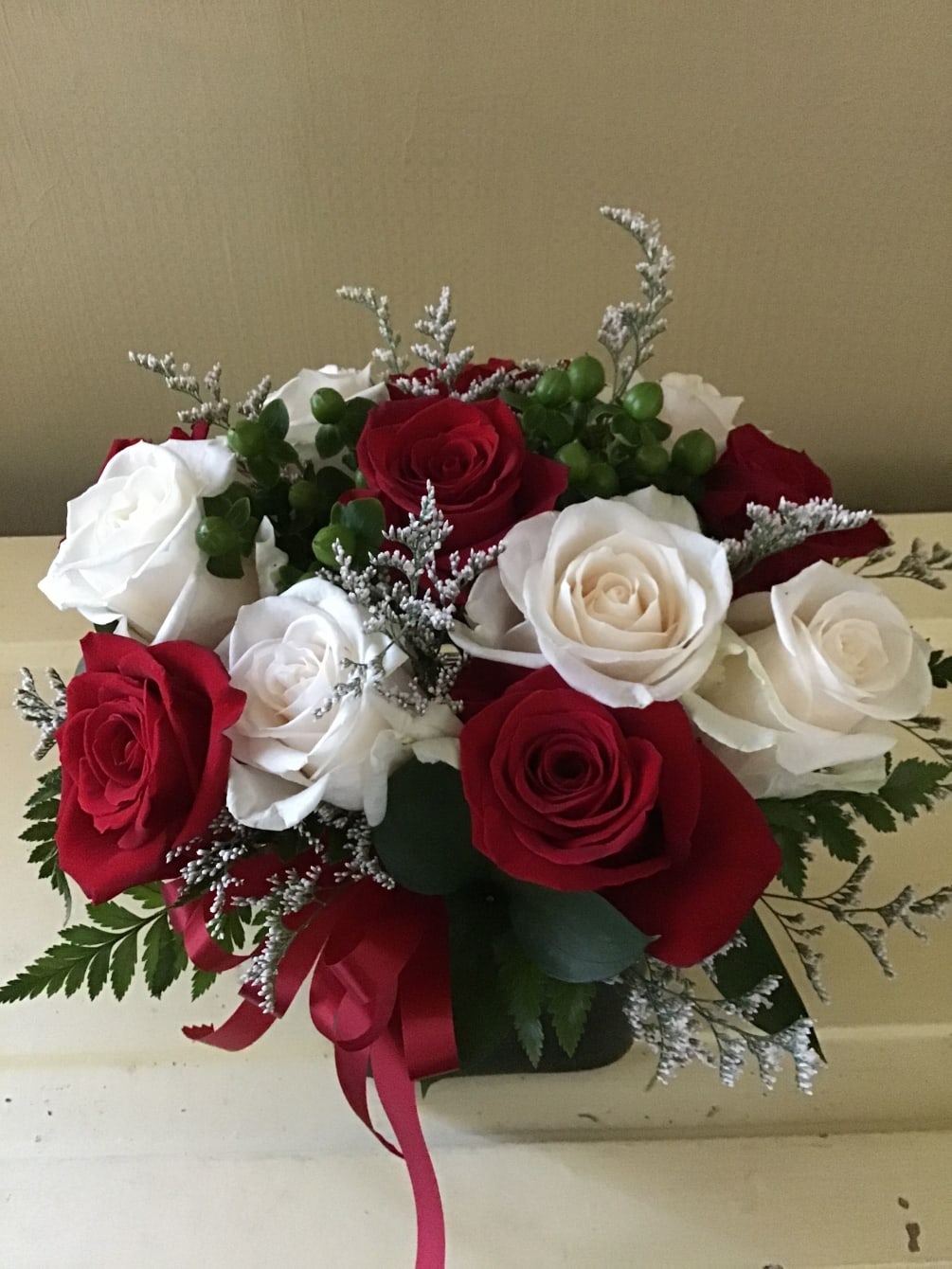 red and white roses in a cube vase 