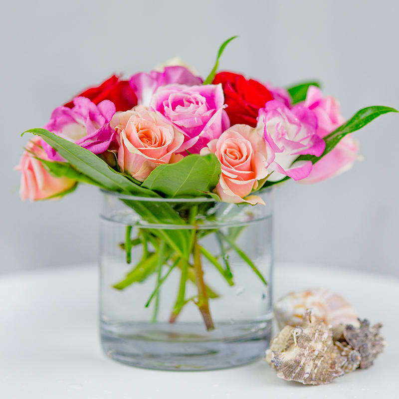 A bouquet of beautiful roses in soft pink, cerise, and red colors.