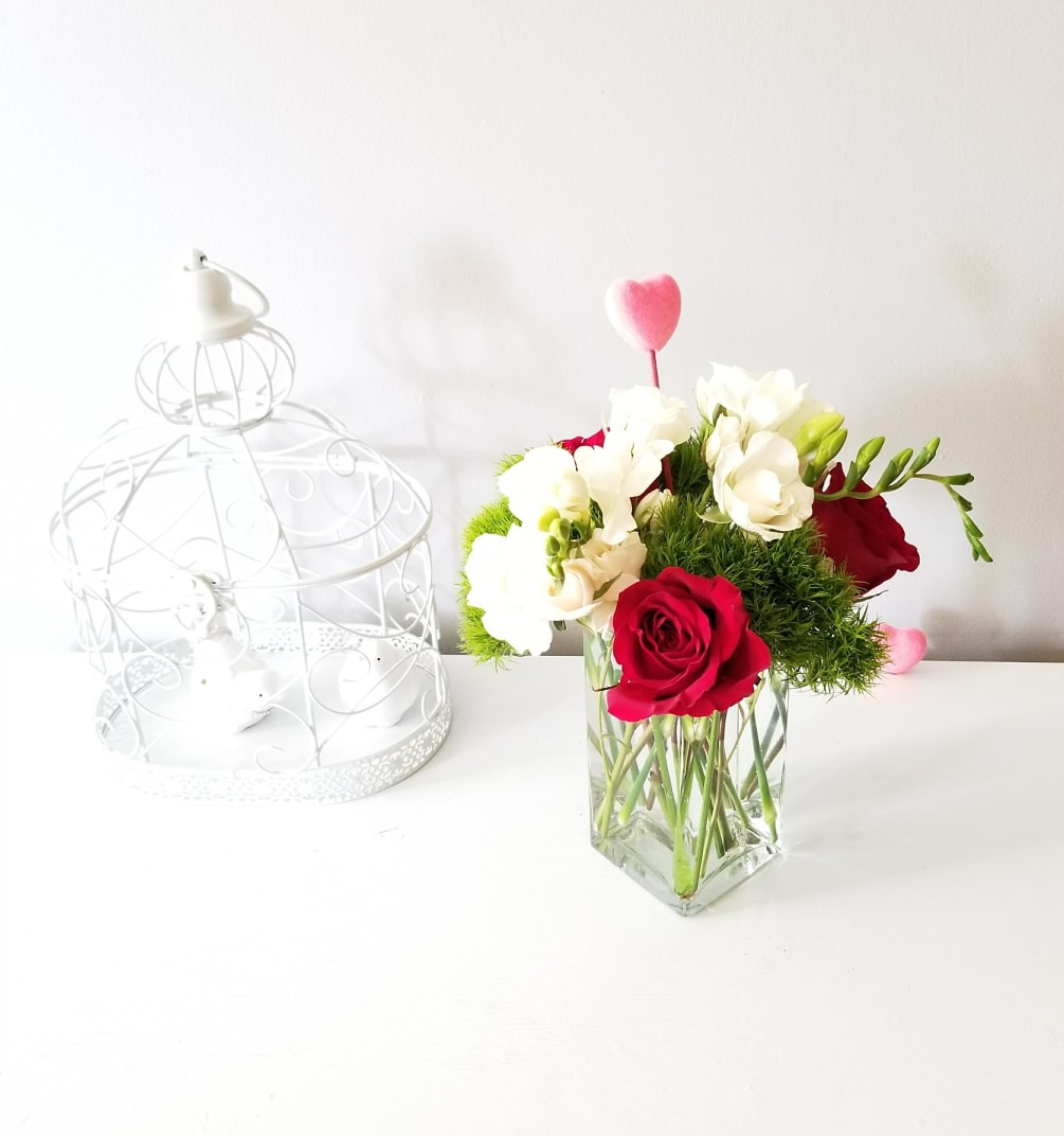 A beautiful arrangement with white freesias, white spray roses, and 3 beautiful