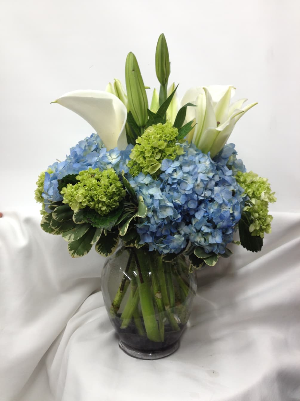 A sophisticated display of fresh elegant flowers handcrafted in a glass vase.