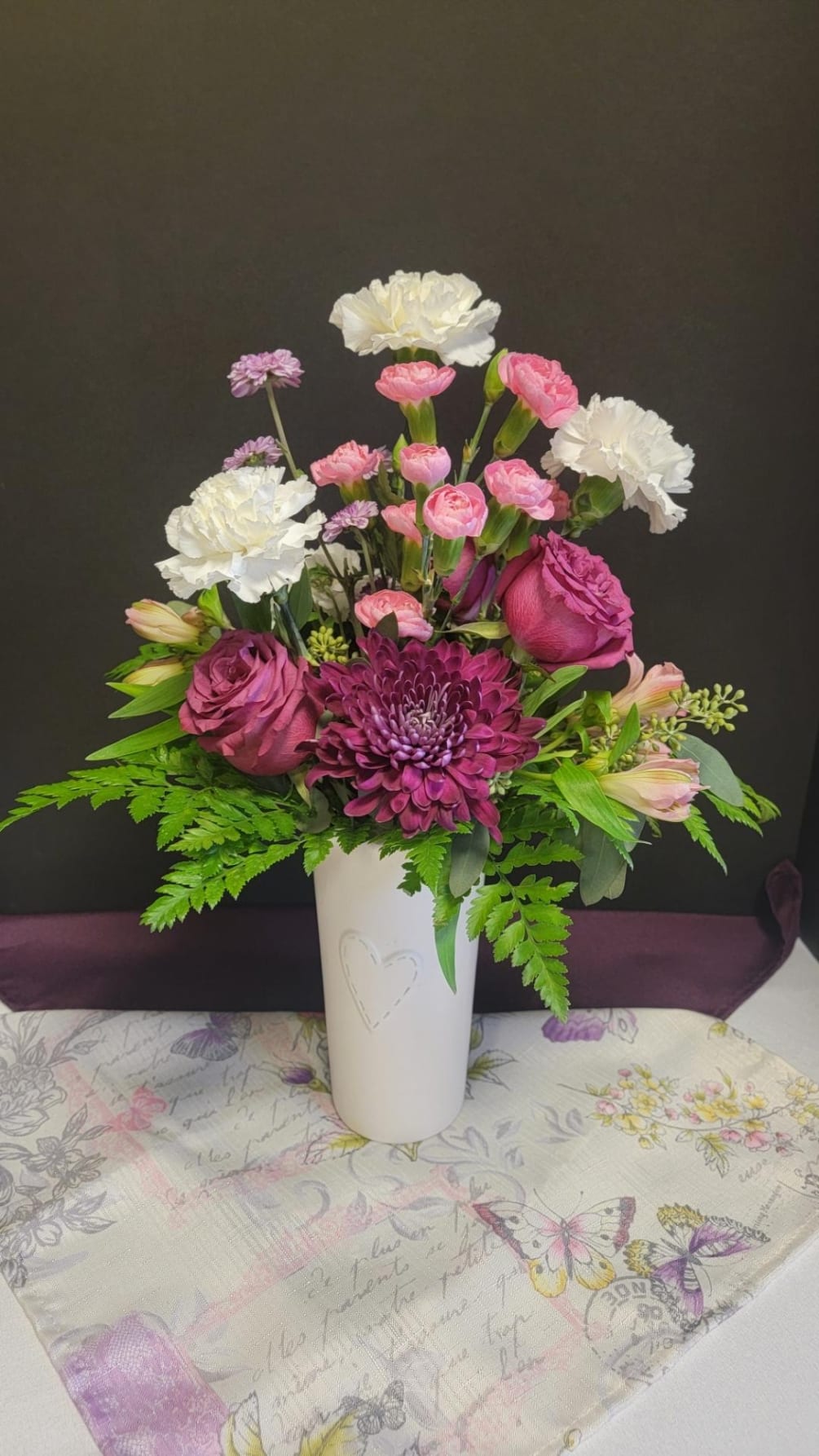 Mix arrangement in a heart white vase, white carnations, blueberry pink roses