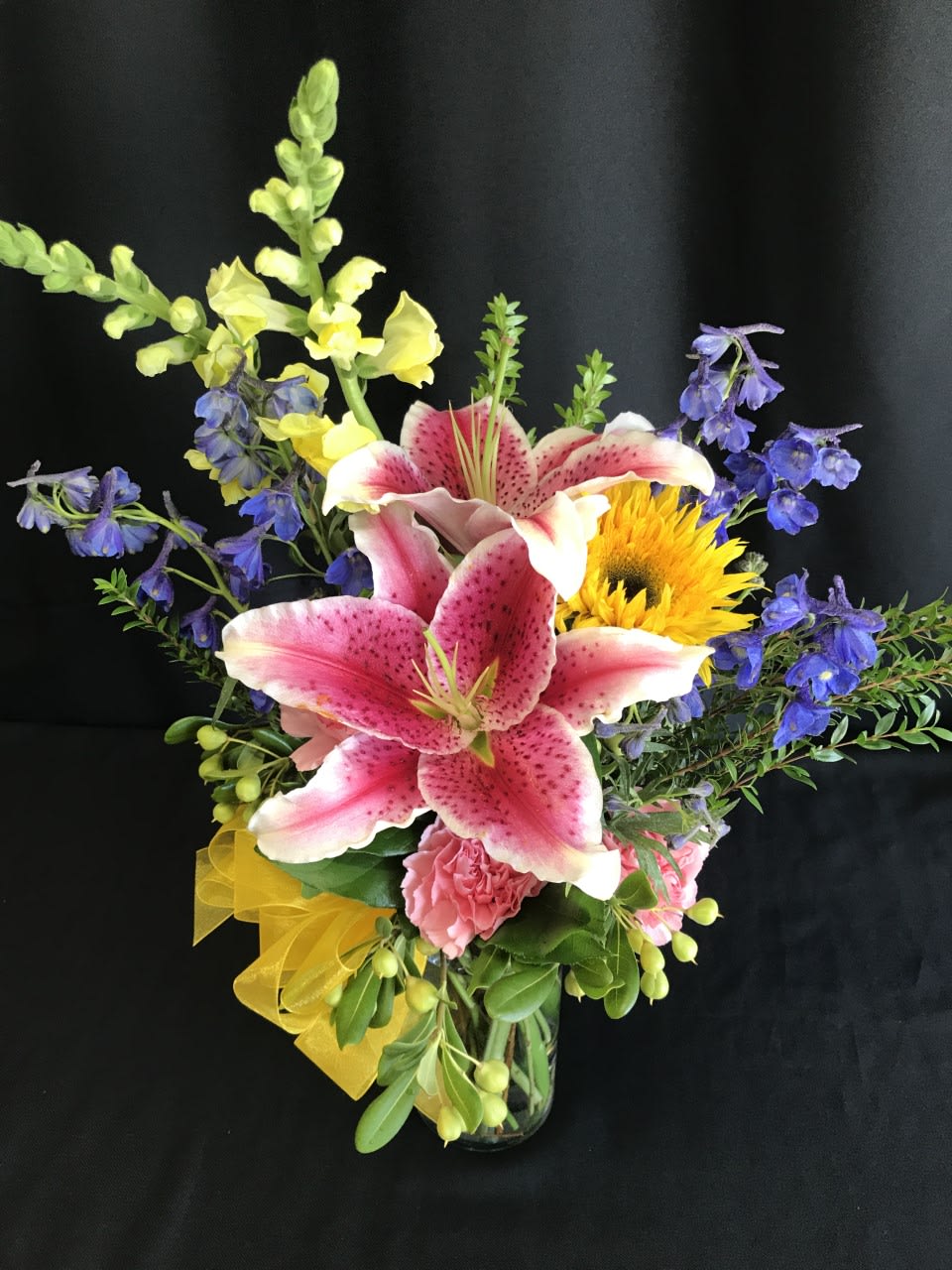 One stargazer lily and some companion flowers in a small vase.
Excellent choice