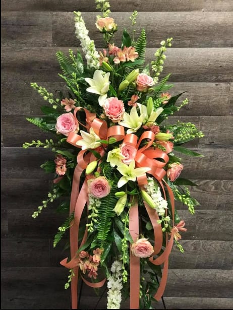This large standing spray features larkspur, roses, lilies and ferns. Can be