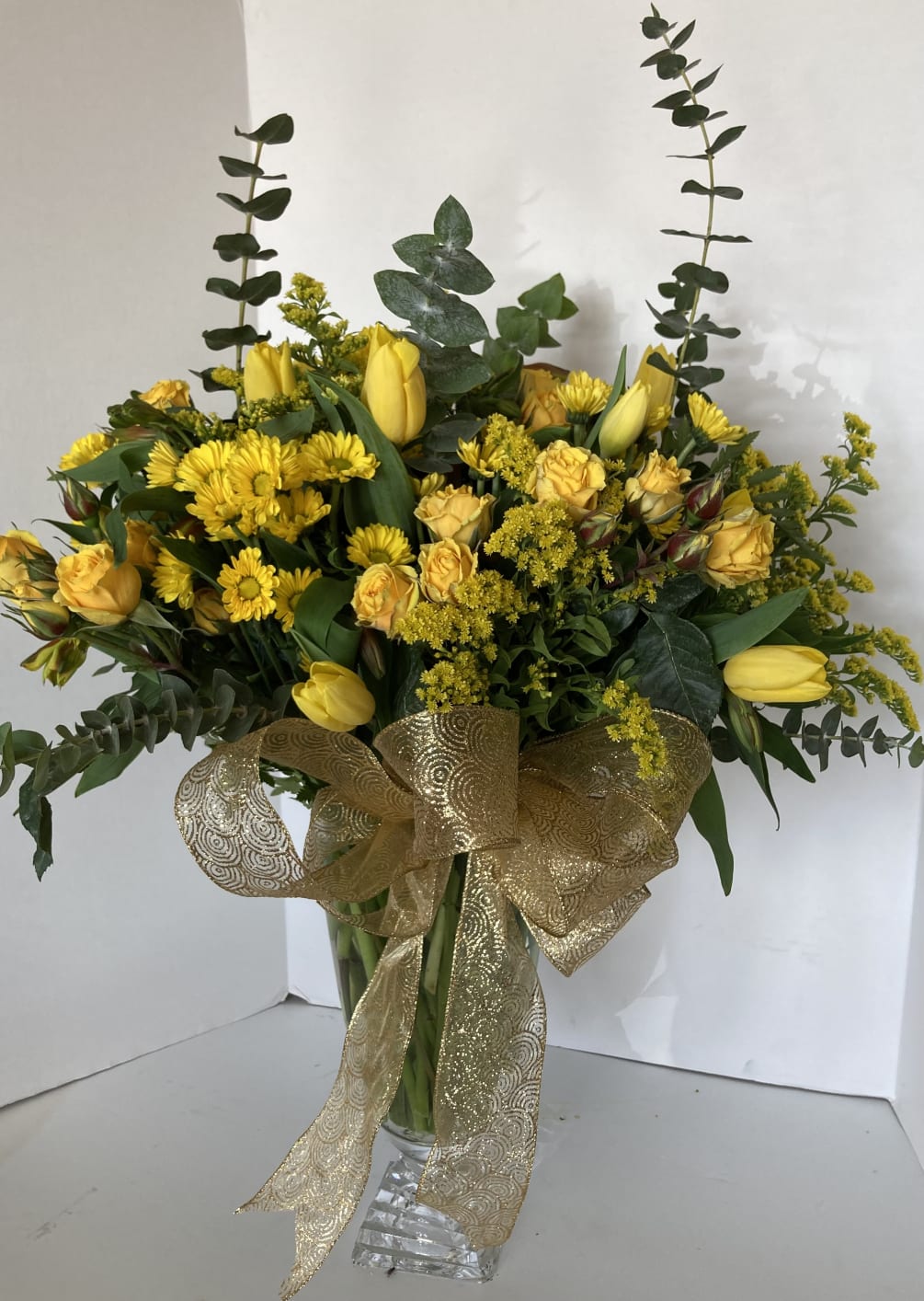 A custom container filled with bright yellow seasonal blooms.