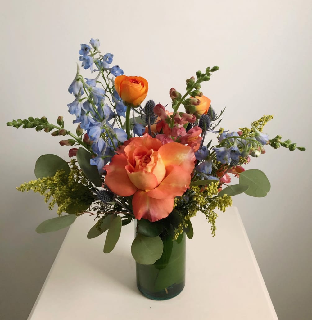 Neptune is a whimsical arrangement with blue and orange flowers that are