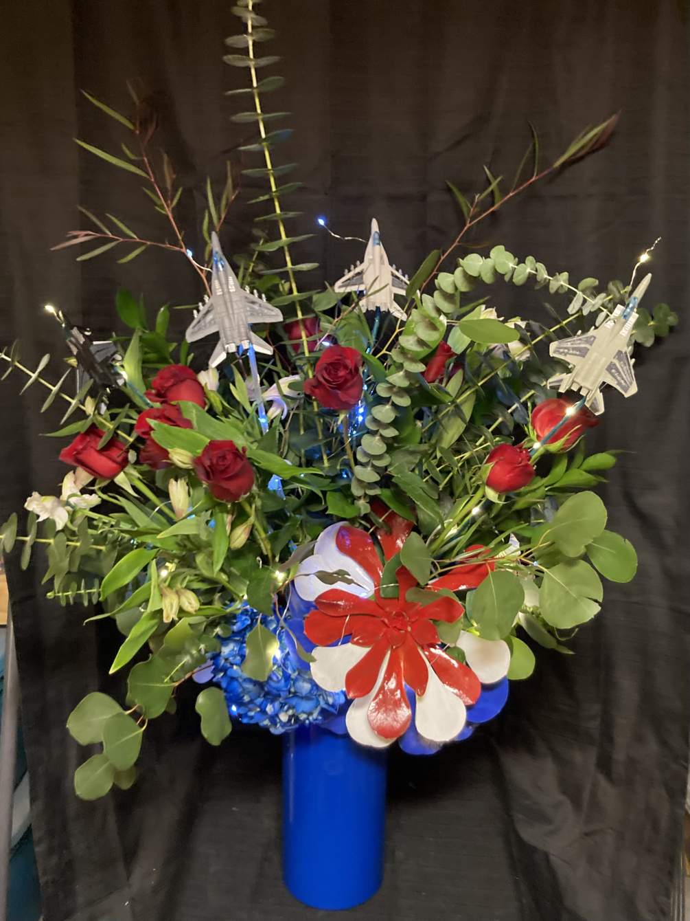Red white and blue flowers arranged in a custom vase.