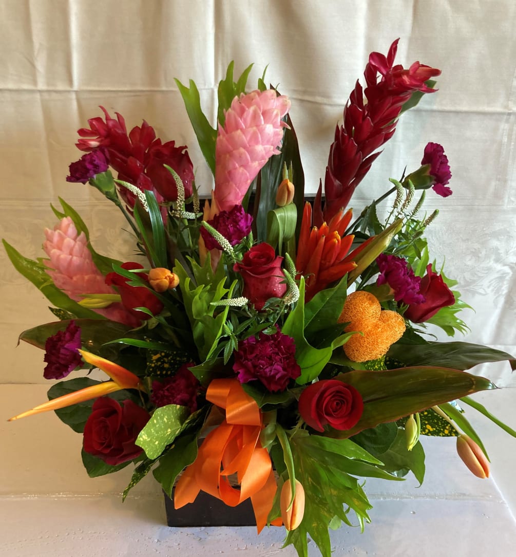 Seasonal Tropical Blooms arranged in a custom container.