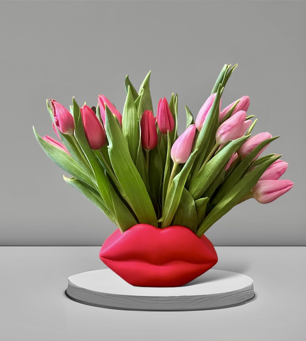 A sweet arrangement of tulips in a festive lips shaped vase. A