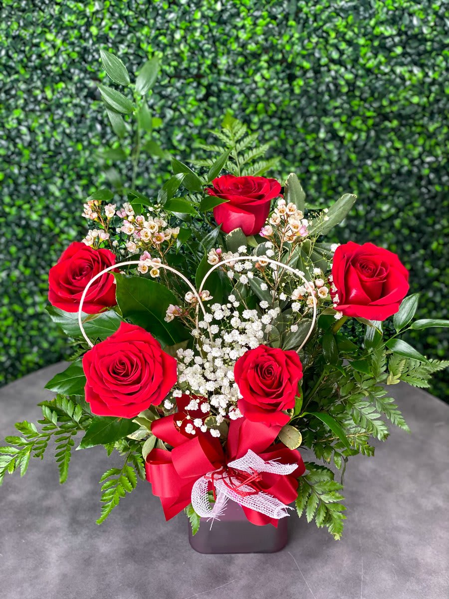 This elegant arrangement features beautiful red roses decorated with baby&#039;s breath, and