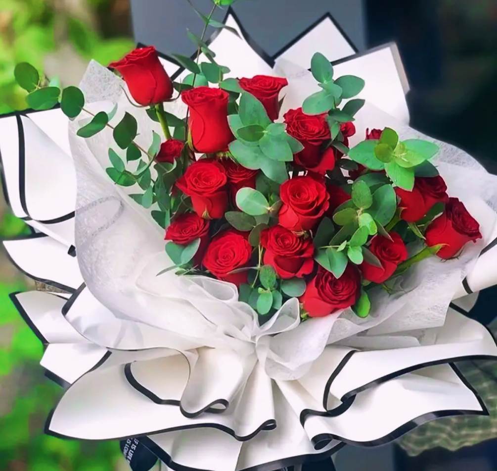 Hand help dozen roses with mixed greens wrapped in beautiful floral paper