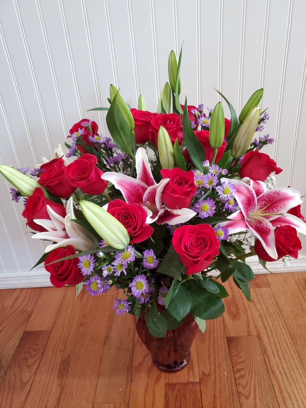 A beautiful vase arrangement in a red or clear vase 24 Rose&#039;s