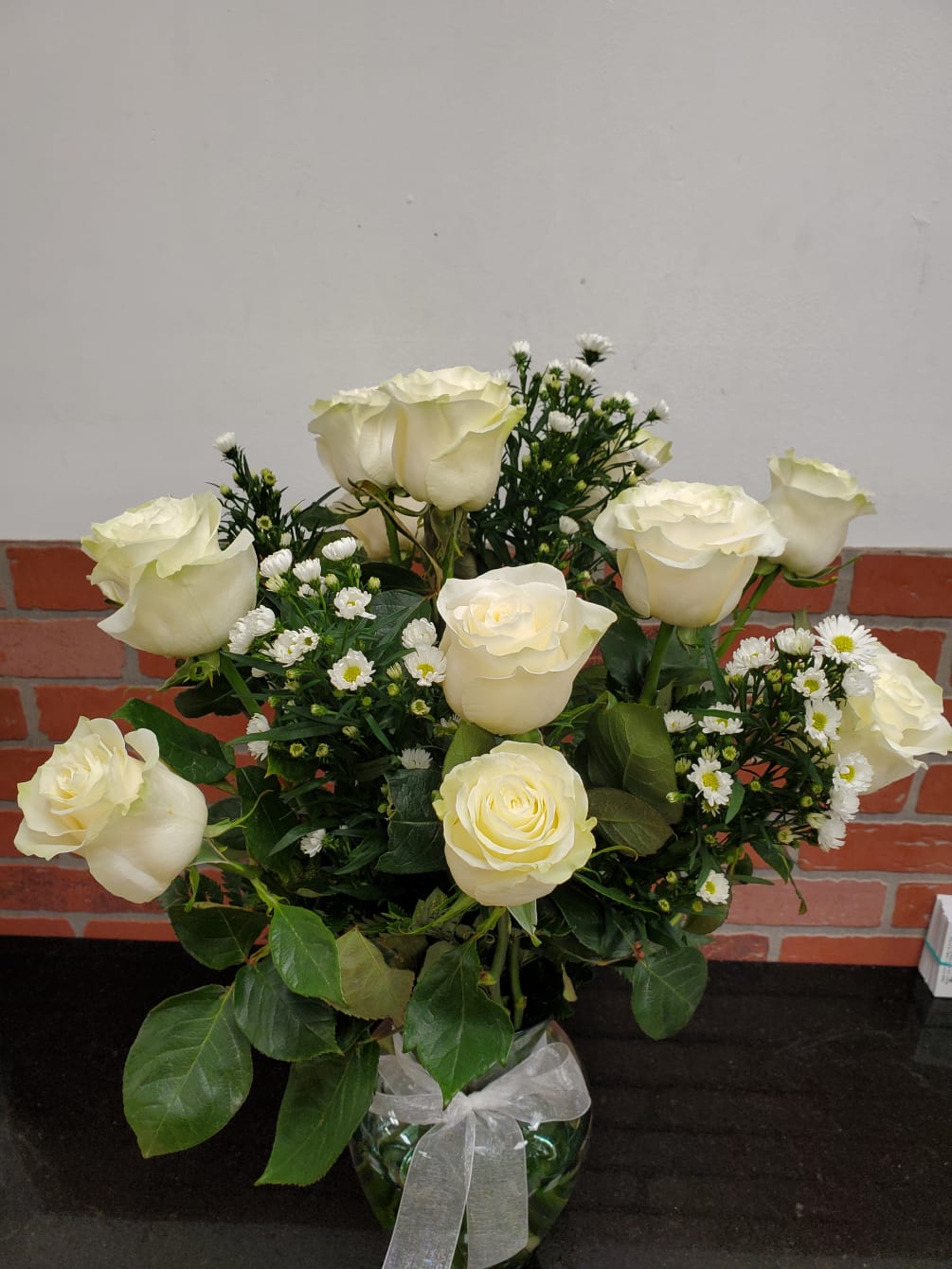 12 white roses in a nice clear vase with white monte casino