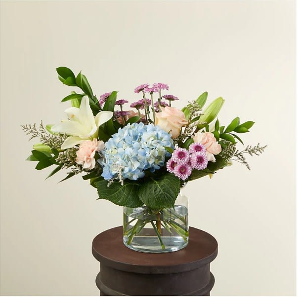 A beautiful arrangement of calming colors pairing perfectly with peach-colored flowers. Available