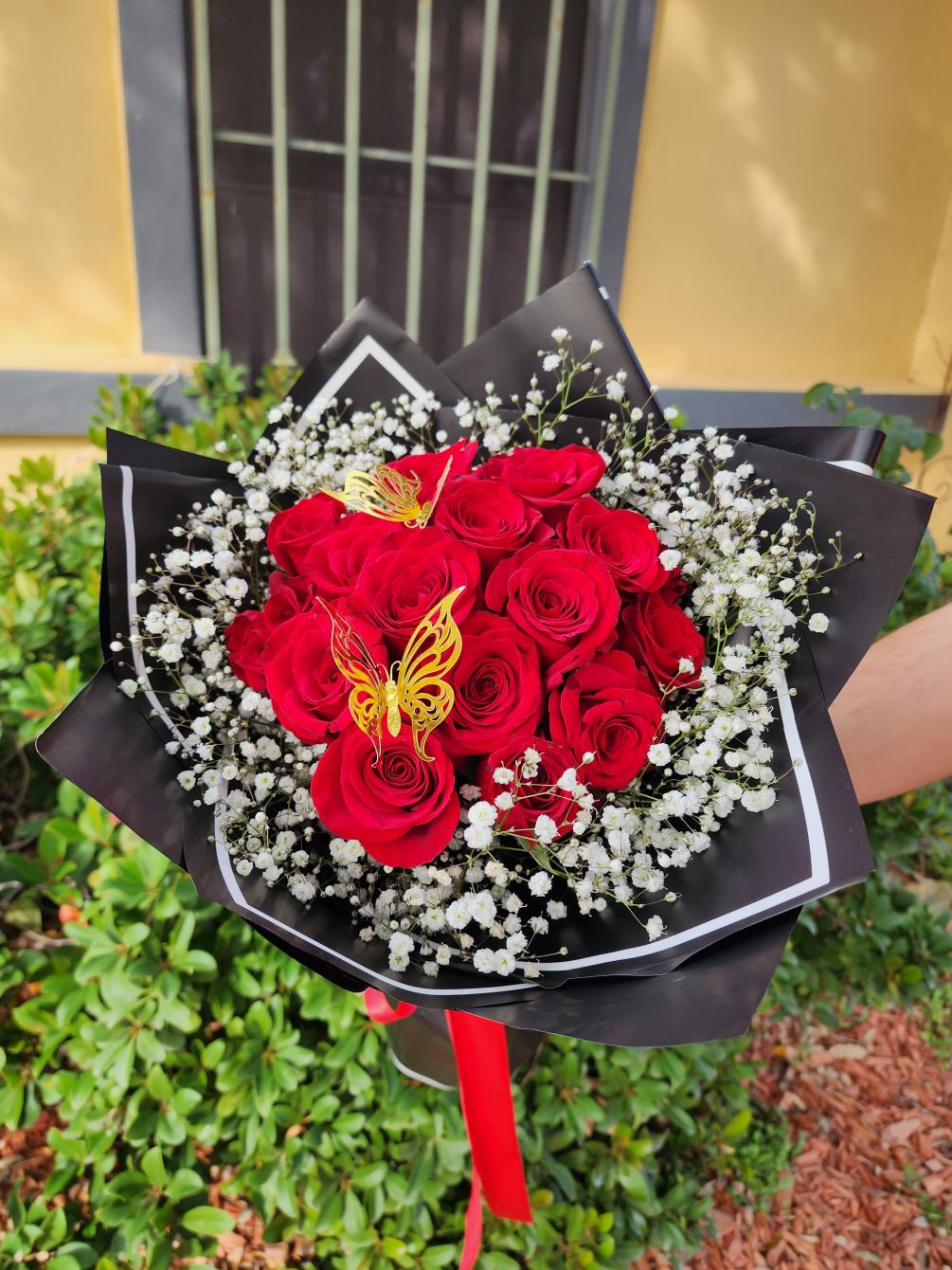 Beautiful wrapped bouquet with 18 red roses, golden butterflies, and a cloud