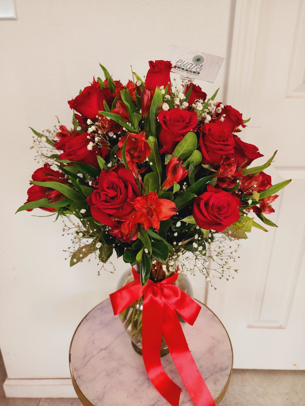 Crystal vase arrangement with 24 red, vivid roses, various stems of red