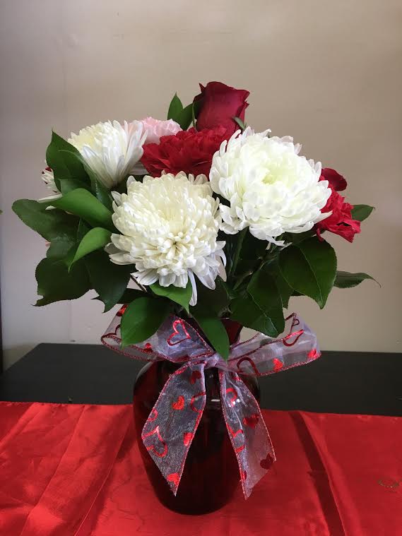 Beautiful arrangement of red and pink carnation, white chrysantemums and red roses.