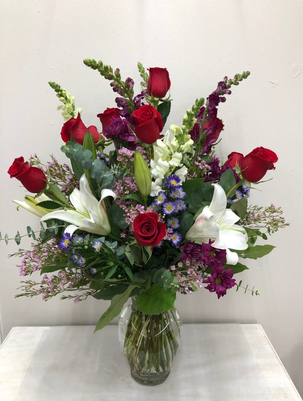 Roses, lilies, snapdragons with daises, wax flower, etc.

Flowers and color may vary