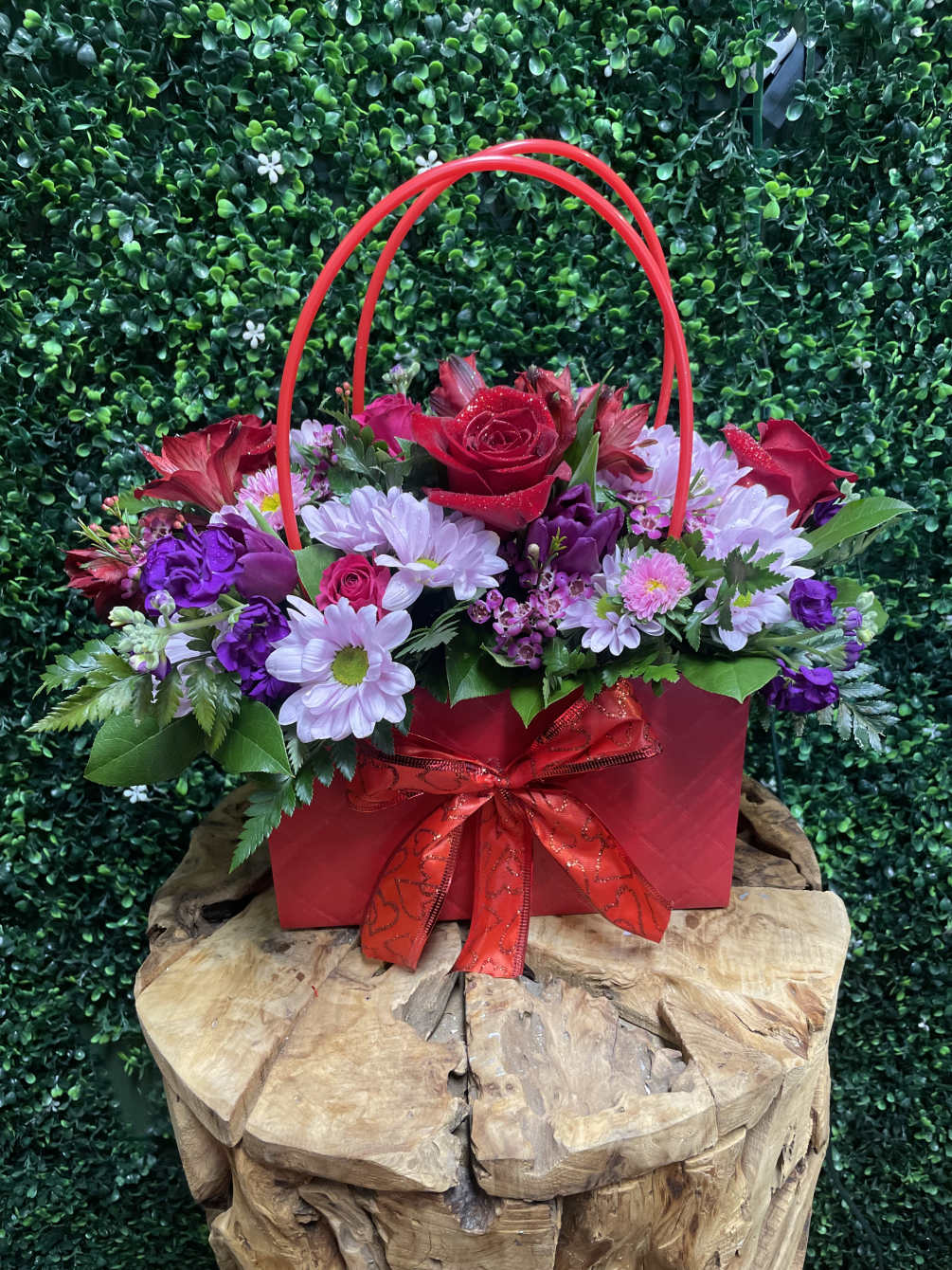 A lovely handbag arrangement filled with seasonal blooms. 