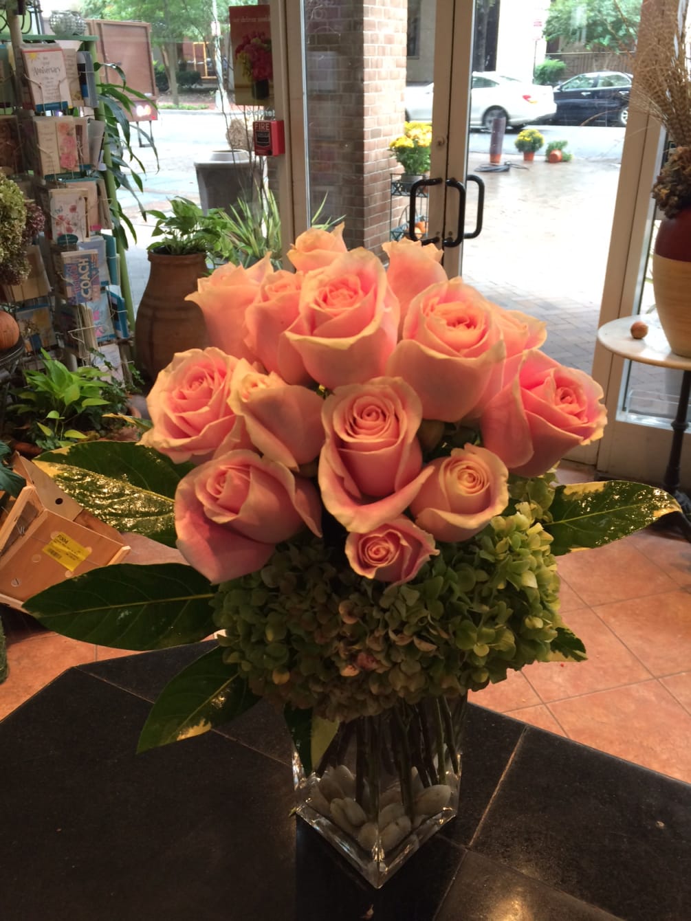 Dozen pink roses with touch of hydrangea , exotic leave, tall vase