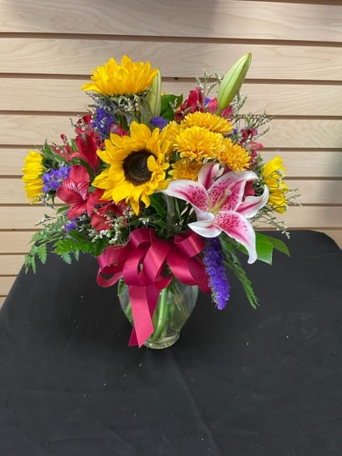 Mixed cut with sunflowers, stargazer lily, red alstroemeria, purple statice, golden cushion